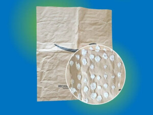 A paper-padded envelope with an overlay showing a magnified view of the small white paper-based padding that lines the envelope.